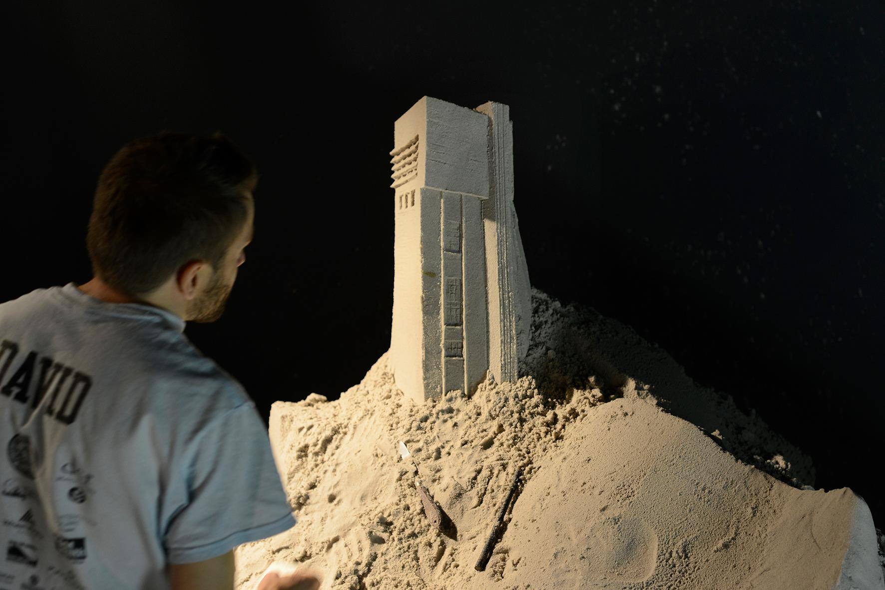 Enguerrand David travaillant sur sa sculpture de sable